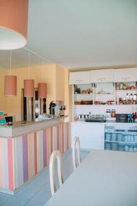 una cucina con bancone, tavolo e sedie di Arca Nova Guest House & Hostel Caminha a Caminha