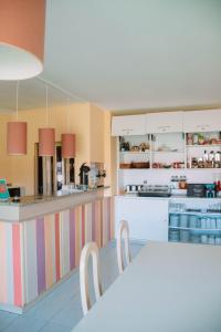 a kitchen with a counter with a table and chairs at Arca Nova Guest House & Hostel Caminha in Caminha