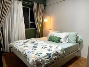 um quarto com uma cama com um edredão e almofadas em Royal Apartment Makassar perfect for family 45m 2BR near Mall Panakkukang Downtown em Pampang