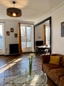 a living room with a couch and a glass table at Le Square vue sur la Sauldre: Châteaux et Beauval in Romorantin