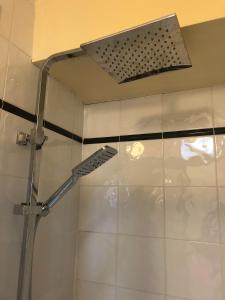 a shower with a shower head in a bathroom at Railway Avenue Rooms in Clifden