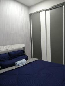 a bedroom with a bed with blue sheets and blue pillows at Aurora Residence @ PUCHONG PRIMA in Puchong