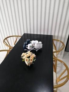 a black table with two chairs and flowers on it at Aurora Residence @ PUCHONG PRIMA in Puchong
