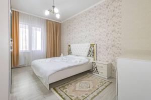 1 dormitorio con 1 cama blanca grande en una habitación en Жк Millennium Park, Большие Апартаменты на площади страны en Astaná