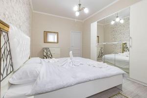 a white bedroom with a large white bed and a mirror at Жк Millennium Park, Большие Апартаменты на площади страны in Astana