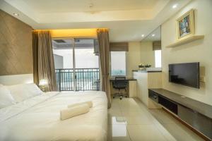 a hotel room with a bed and a television at Modern & comfy studio in central Jakarta, SCBD in Jakarta