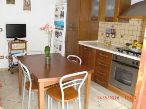 kuchnia ze stołem, krzesłami i lodówką w obiekcie B&B Il Giardinetto Alghero w mieście Alghero