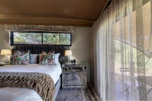 a bedroom with two beds and a large window at Oase by 7 Star Lodges - Greater Kruger Private 530ha Reserve in Hoedspruit