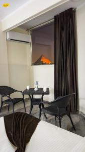 Zimmer mit 2 Stühlen, einem Tisch und einem Fenster in der Unterkunft Happy View Inn in Kairo