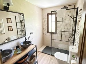een badkamer met 2 wastafels en een glazen douche bij La Fontanilla en Estación de El Espinar in Segovia