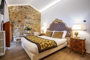 a bedroom with a large bed and a stone wall at Residenza le Colline del Paradiso in Bivigliano