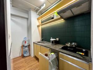 uma cozinha com um fogão e uma parede de azulejos verdes em Royal Apartment Makassar perfect for family 45m 2BR near Mall Panakkukang Downtown em Pampang