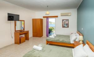 a bedroom with a bed and a desk and a television at Zenstay Hotel in Áyios Nikólaos Nirás