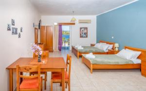 Habitación con 2 camas, mesa y comedor. en Zenstay Hotel en Áyios Nikólaos Nirás