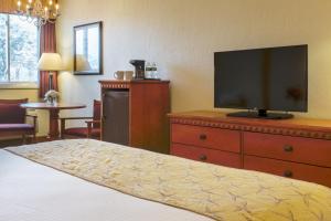 a bedroom with a bed and a television on a dresser at Bayside Resort Hotel in West Yarmouth