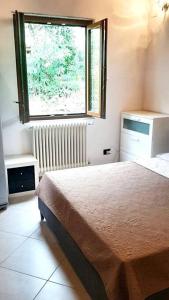 1 dormitorio con cama y ventana en casa di arya CODICE CITRA LT-0043, en Vescina
