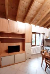una cocina con armarios de madera y una mesa. en casa di arya CODICE CITRA LT-0043, en Vescina