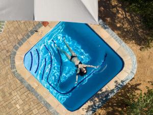 a person swimming in a pool in a swimming pool at Oase by 7 Star Lodges - Greater Kruger Private 530ha Reserve in Hoedspruit