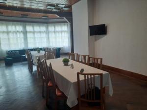 a dining room with tables and chairs and a television at Vila Viorica in Sovata