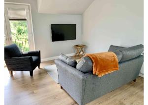 sala de estar con sofá y silla en Acorn Attic, a modern, new first floor garden annex, en Great Ouseburn