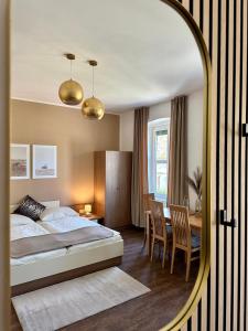 Schlafzimmer mit einem Bett, einem Tisch und einem Spiegel in der Unterkunft Johnys Jungle in Marbach an der Donau