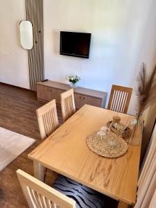 mesa de comedor de madera con sillas y TV en Johnys Jungle en Marbach an der Donau