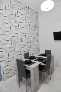 tavolo e sedie in una stanza con parete di Margò Luxury a Mola di Bari