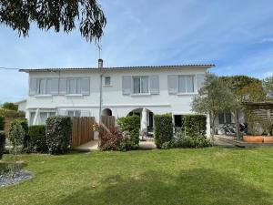 a white house with a fence and a yard at Vacances Sur Mer in Saint-Palais-sur-Mer