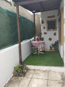 een patio met een tafel, een tafel en een hek bij Fay's House in Mesagrós