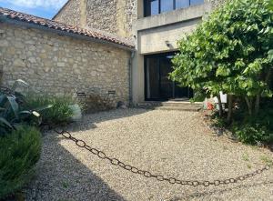 a chain in front of a house with a building at Le clos du Mesnil, Logement totalement indépendant in Le Tourne