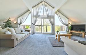 a living room with a couch and a large window at Puffin Hot tub Lodge, 4 bedrooms Resort, Pool,Gym,Bar in Padstow