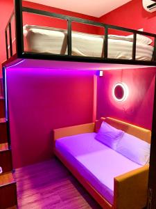 - une chambre avec des lits superposés et un éclairage violet dans l'établissement Arena eSports Hotel @ Bugis Village, à Singapour