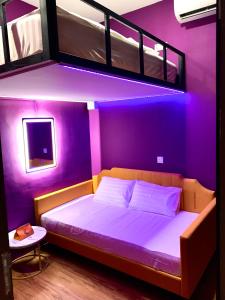 a bedroom with a purple room with a bunk bed at Arena eSports Hotel @ Bugis Village in Singapore