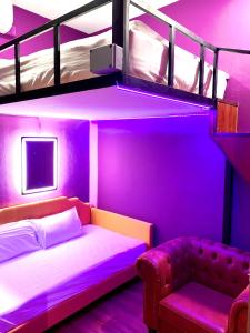 um quarto roxo com um beliche e um sofá em Arena eSports Hotel @ Bugis Village em Singapura