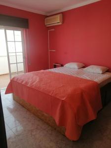 um quarto vermelho com uma cama com uma parede vermelha em Vila with Private Pool em Vila Real de Santo António