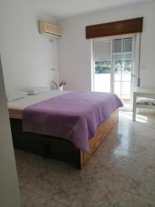 um quarto com uma cama com um cobertor roxo em Vila with Private Pool em Vila Real de Santo António