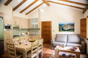 BelesarにあるEl balcón de la Penelaのキッチンとテーブルとソファのあるリビングルーム
