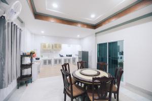 uma cozinha e sala de jantar com mesa e cadeiras em Paradise Found - Hat Yai 292sqm Family Home em Hat Yai