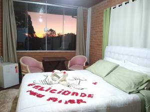 a bedroom with a bed with roses on it at All Green Residence in Monte Verde