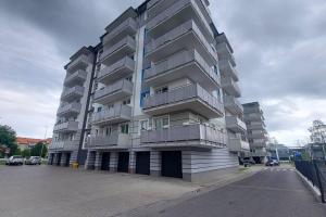 un gran edificio de apartamentos con balcones y aparcamiento en Nowiutki apartament z bezpłatnym parkingiem, en Rumia