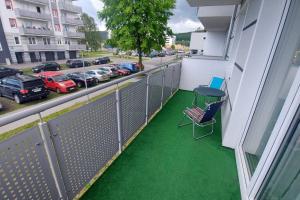 a balcony with green flooring and a table and chairs at Nowiutki apartament z bezpłatnym parkingiem in Rumia