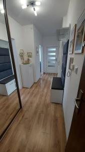 sala de estar con sofá y espejo en Nowiutki apartament z bezpłatnym parkingiem, en Rumia