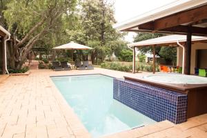 a large swimming pool with a hot tub in a yard at Remhoogte Mountain Lodge in Jacksonstuin