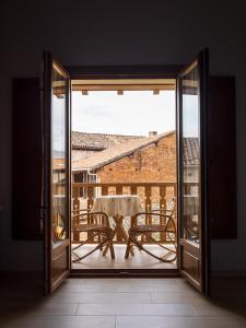 an open door to a patio with a table on a balcony at Casa Rural Picu Llagos in Cangas de Onís
