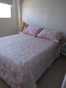 1 dormitorio con 1 cama con edredón rosa en Departamento macrocentro Santa Fe en Santa Fe