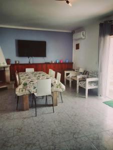 comedor con mesas y sillas y TV de pantalla plana en Vila with Private Pool en Vila Real de Santo António