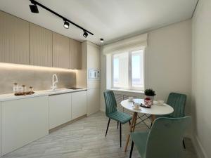 巴甫洛達爾的住宿－LUX с видом на набережную，厨房配有桌椅和水槽。