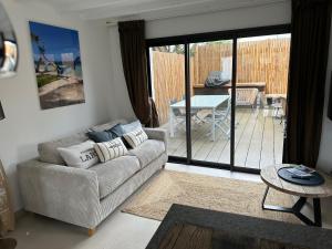a living room with a couch and a table at Le cache a l eau in Le Pouliguen