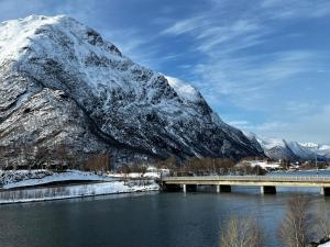 a bridge over a river with a snow covered mountain at Frichs Ekspress Åndalsnes in Åndalsnes +44 photos