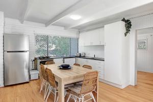 a kitchen with a table and chairs and a refrigerator at Billa Bungalow - 16 Billa Street in Point Lookout